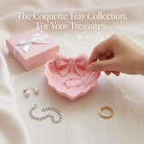 A heart-shaped jewelry tray with a pink bow, made using 3D printing technology, is suitable for placement on a dressing table, s